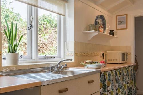 uma cozinha com um lavatório e uma janela em Cliffeside Cottage em Kingsdown