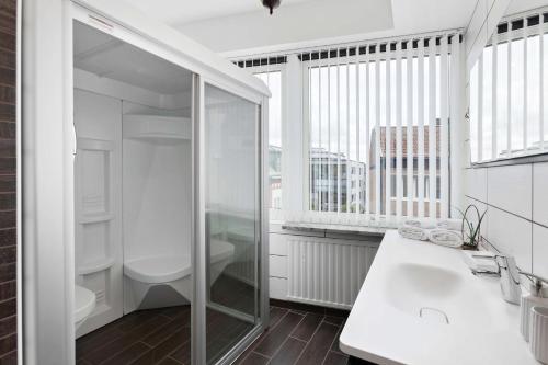 a bathroom with a glass shower and a toilet at Best Western Vetlanda Stadshotell in Vetlanda