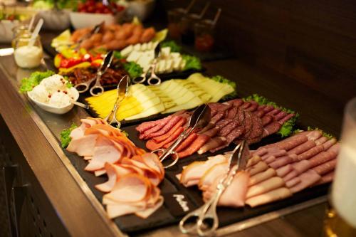 a buffet with many different types of meats and cheese at Green Resort Suncuius in Şuncuiuş