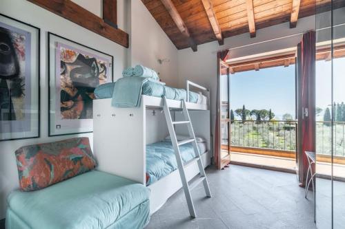 una camera con letti a castello e un balcone di Casa Peler al Benaco - Style, Lake view & Pool a Toscolano Maderno