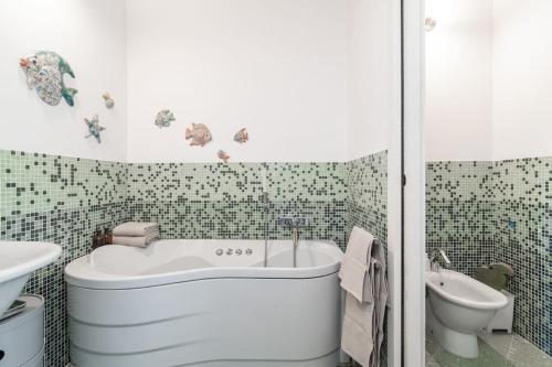 e bagno con vasca, servizi igienici e lavandino. di Casa Peler al Benaco - Style, Lake view & Pool a Toscolano Maderno