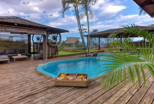 a pool with a basket of fruit next to a house at Villa Bri in Rivière