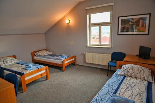 a room with three beds and a window at Tarnowskie Centrum Informacji in Tarnów