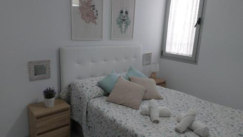 Un dormitorio con una cama con almohadas encima. en Casa Palba, en Conil de la Frontera