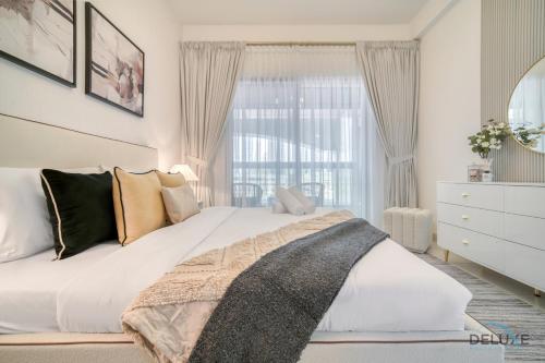 a bedroom with a large white bed and a window at Harmonious 1BR at Al Shera Tower JLT by Deluxe Holiday Homes in Dubai