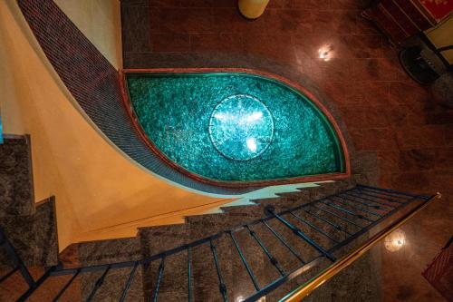a spiral staircase with a green pool of water at Wellnesshotel Schönruh - Adults only in Seefeld in Tirol