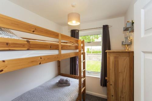 - une chambre avec 2 lits superposés et une fenêtre dans l'établissement BRAUNTON BEACON VIEW 3 Bedrooms, à Braunton