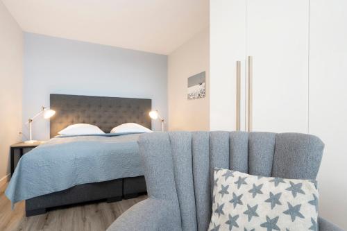 - une chambre avec un lit bleu et une chaise dans l'établissement Berolina Wohnung 405, à Dahme