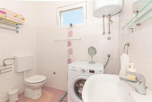 een badkamer met een wasmachine en een wastafel bij Apartment Milka in Zaton