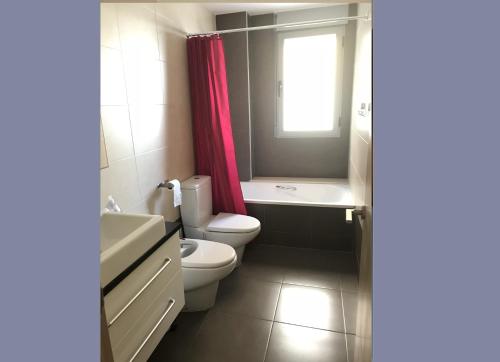 a bathroom with a toilet and a sink and a window at Stunning 2-Bed Apartment in Pego in Pego