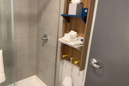 a bathroom with a shower and a toilet and a sink at Microtel Inn & Suites by Wyndham Rehoboth Beach in Rehoboth Beach