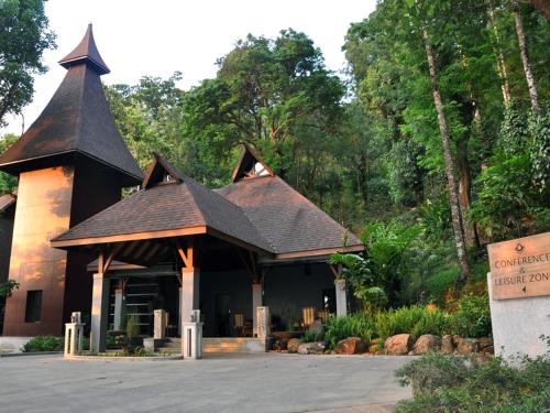 a small building with a roof on a street at The Tamara Coorg in Kakkabe