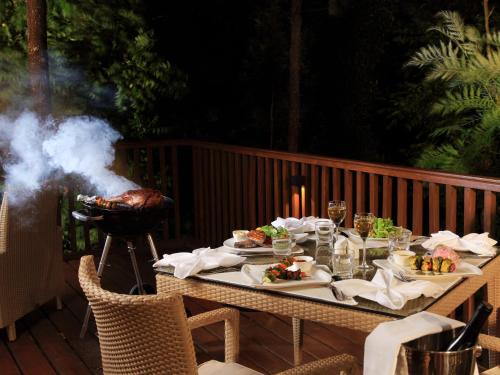 a table with food and a grill on a deck at The Tamara Coorg in Kakkabe