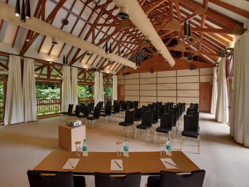 a conference room with tables and chairs and windows at The Tamara Coorg in Kakkabe