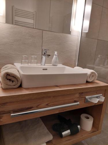 a bathroom with a white sink and a mirror at Landhaus Gerber in Lermoos