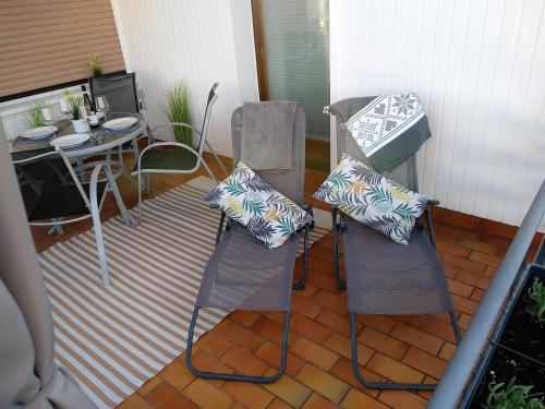a patio with two chairs and a table and a table at Ferienwohnungen Op der Kees in Irsch