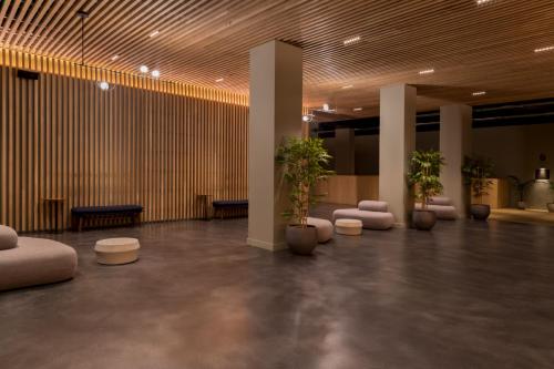 a lobby with a row of plants and chairs at Zedwell Hotel Piccadilly Circus in London