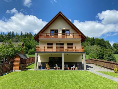 a house with a balcony and a yard at Górskie Zacisze in Zawoja