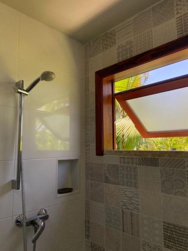 a bathroom with a shower with a window and a shower head at Flat - SERRA E MAR - Paraty in Paraty