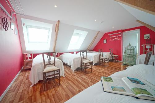 a room with four beds and a table and chairs at Gîte du Jardin in Theux
