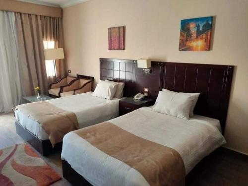 シャルム・エル・シェイクにあるUni sharm aqua parkのベッド2台とデスクが備わるホテルルームです。