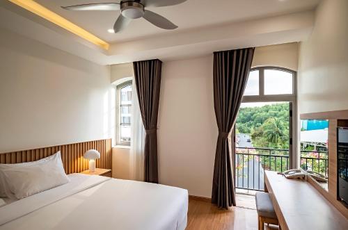 a bedroom with a bed and a large window at Ann Hotel & Spa Khem Beach PQ in Phu Quoc