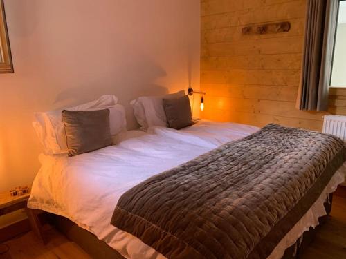 sypialnia z dużym łóżkiem z białą pościelą w obiekcie Pom Pom, 3 bedroom apt with stunning mountain views-Samoëns w mieście Samoëns
