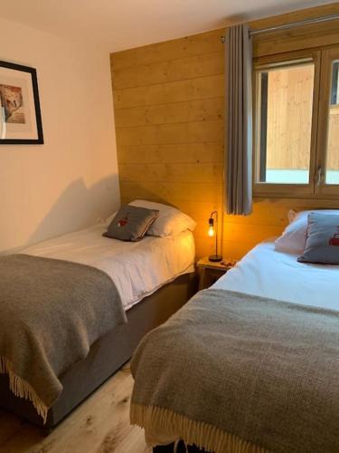 une chambre avec deux lits et une fenêtre dans l'établissement Pom Pom, 3 bedroom apt with stunning mountain views-Samoëns, à Samoëns
