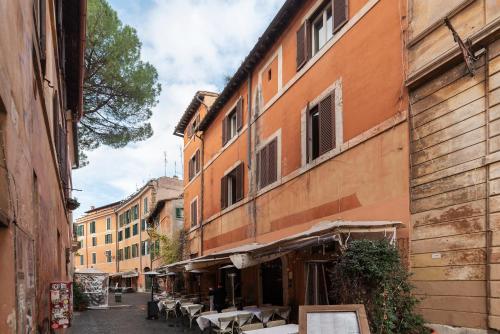 an alley with tables and chairs next to a building at Luxury Trastevere in Rome