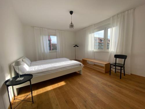 1 Schlafzimmer mit einem Bett, einem Schreibtisch und 2 Stühlen in der Unterkunft Appartement NikTen in Friedrichshafen