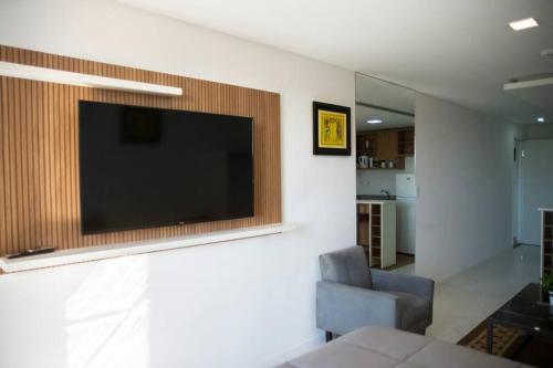 uma sala de estar com uma televisão de ecrã plano na parede em Bello Monoambiente ZV212, Edif Zetta Village Airport em Colonia Mariano Roque Alonso