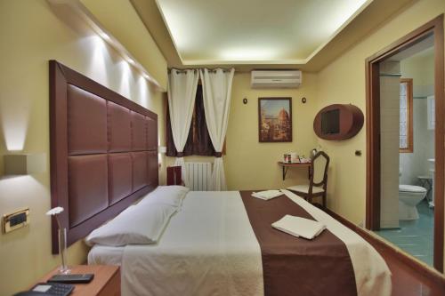 a bedroom with a large bed and a bathroom at EuroHome in Signa