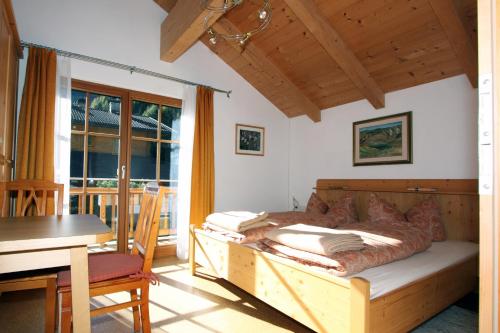 een slaapkamer met een bed, een tafel en een bureau bij Haus Lubach in Kals am Großglockner
