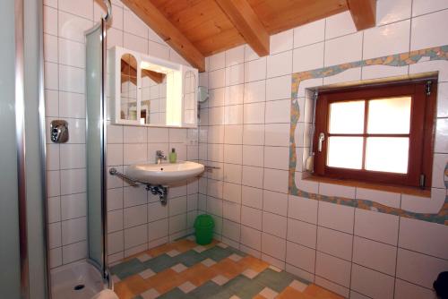 a bathroom with a sink and a shower with a window at Haus Lubach in Kals am Großglockner