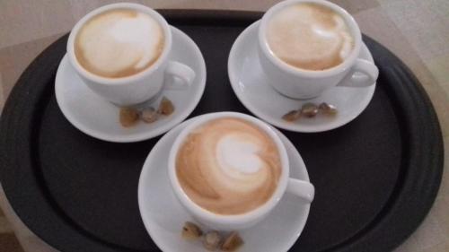 three cups of coffee on a black tray at B&B Villa Nonna Maria in Castellana Grotte