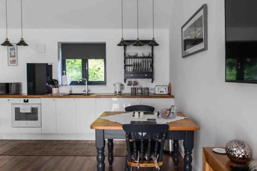 eine Küche mit einem Tisch und einigen Stühlen in der Unterkunft Open plan Stylish Apartment in rural Kent in Kent