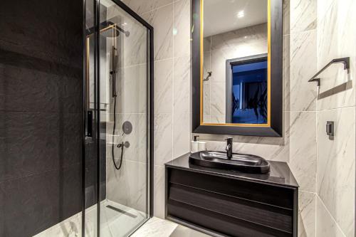 y baño con lavabo y ducha con espejo. en Modern Apartment in Beyoglu with Balcony, en Estambul