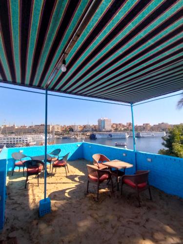 a patio with tables and chairs and a view of a river at Jamaica Guest House in Aswan