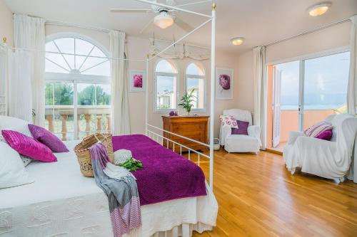 una camera da letto con un grande letto con una coperta viola di Sa Marina a Alcudia
