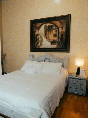 a bedroom with a white bed with a picture on the wall at Salamina Highs in Salamina