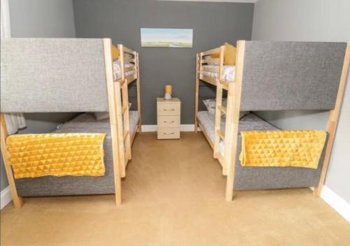 um quarto com três beliches num quarto em Ffynonn Wen em Llandrillo-yn-Rhôs