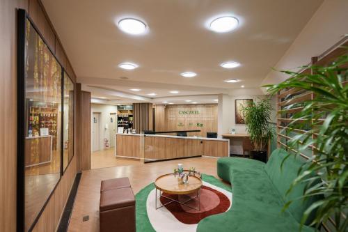 a living room with a green couch and a table at Central Park Hotel by Bourbon Cascavel in Cascavel