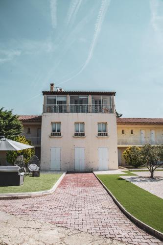 a house with a brick driveway in front of it at Hôtel Castel Saint Anne in Le Castellet