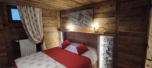 a bedroom with a bed in a wooden cabin at La Maison Derby in La Salle
