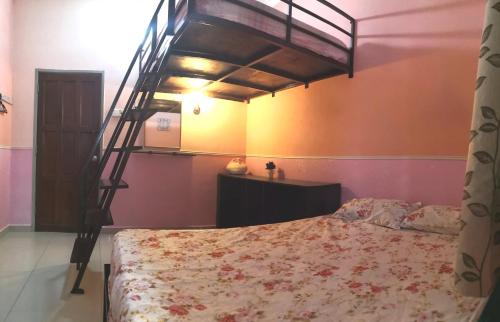 a bedroom with a bunk bed with a bedspread at Hua Tang Homestay in Ipoh