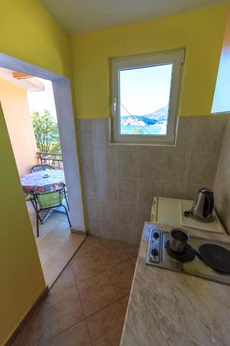 a small kitchen with a stove and a window at Apartments Vitic in Sutomore