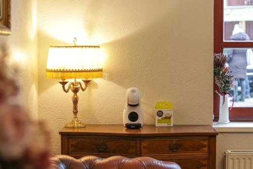 a table with a lamp and a alarm clock on it at Apple Economy Hotel in Kaunas