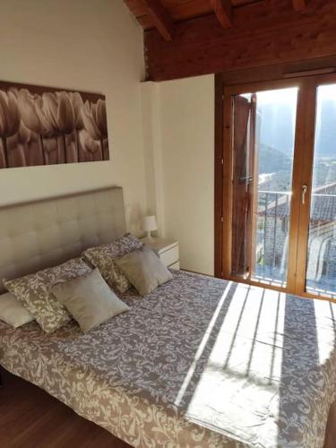 a bedroom with a bed and a sliding glass door at Casa Balcón de Los Pirineos - Gavín Biescas in Gavín