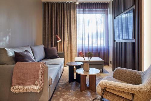 a living room with a couch and a chair at Original Sokos Hotel Valjus Kajaani in Kajaani