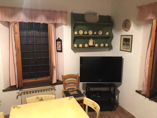 a living room with a television and a table and chairs at VACANZE A SESTOLA in Sestola